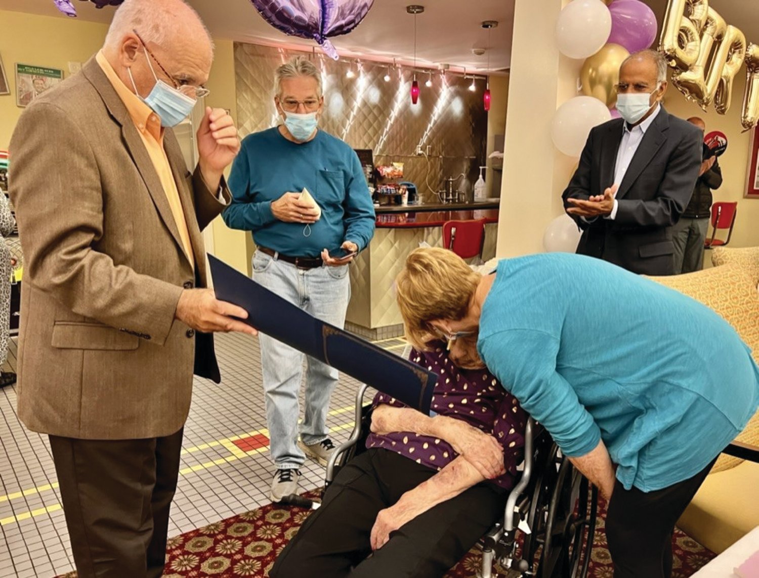 IT’S OFFICIAL: Johnston Mayor Joseph Polisena presented Joan Ruberg with a commemoration of her 100th birthday while her son-in-law Michael Nahod, Akshay Talwar and her daughter Carol Nahod look on.